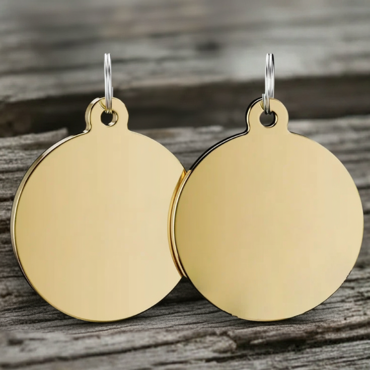 Gold round dog tags on a wooden surface