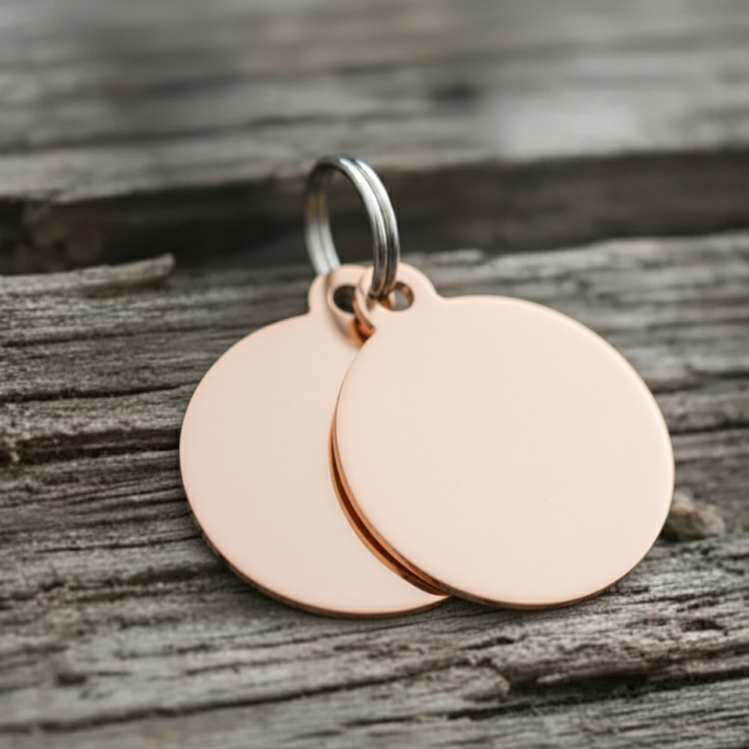 Rose gold dog tags on a wooden surface