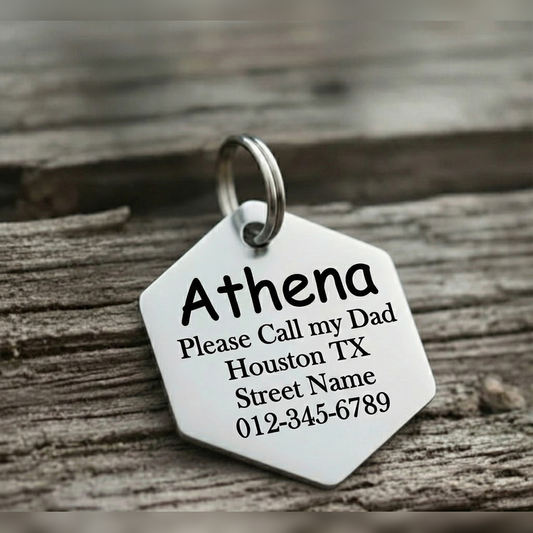 Hexagonal metal tag with engraved text on a wooden surface